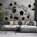 Fotobehang Voetballen die door de muur breken.