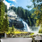 Fotobehang Bergwaterval te midden van weelderig groen bos