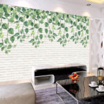 Fotobehang Witte bakstenen muur met groene bladeren