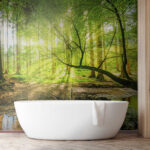 Fotobehang Zonovergoten bos met glinsterend beekje.