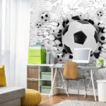 Fotobehang Voetballen barsten door de muur.