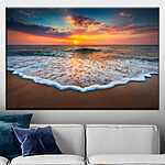 Canvas Schilderijen Golven bij zonsondergang omhelzen de kust.