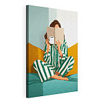 Canvas Schilderijen Vrouw die op een bed zit met een boek en een mok